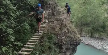 two people on via feratta route, one person crossing bridge